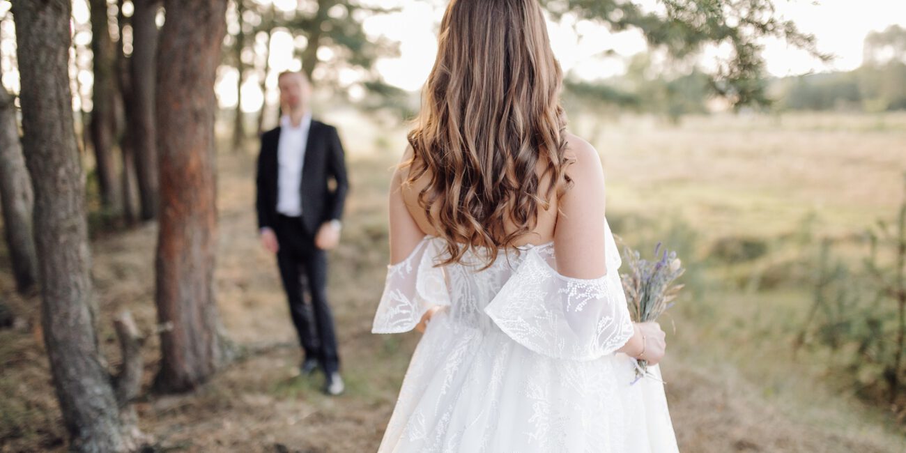 Braut von hinten blickend auf Bräutigam