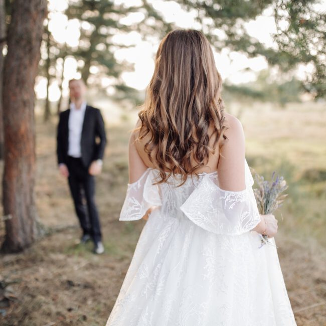 Braut von hinten blickend auf Bräutigam